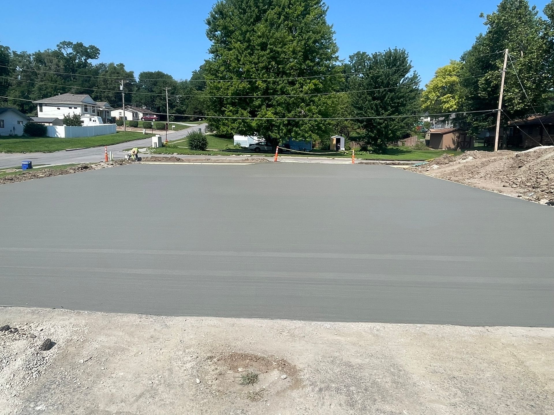 A concrete driveway with a lot of trees in the background.