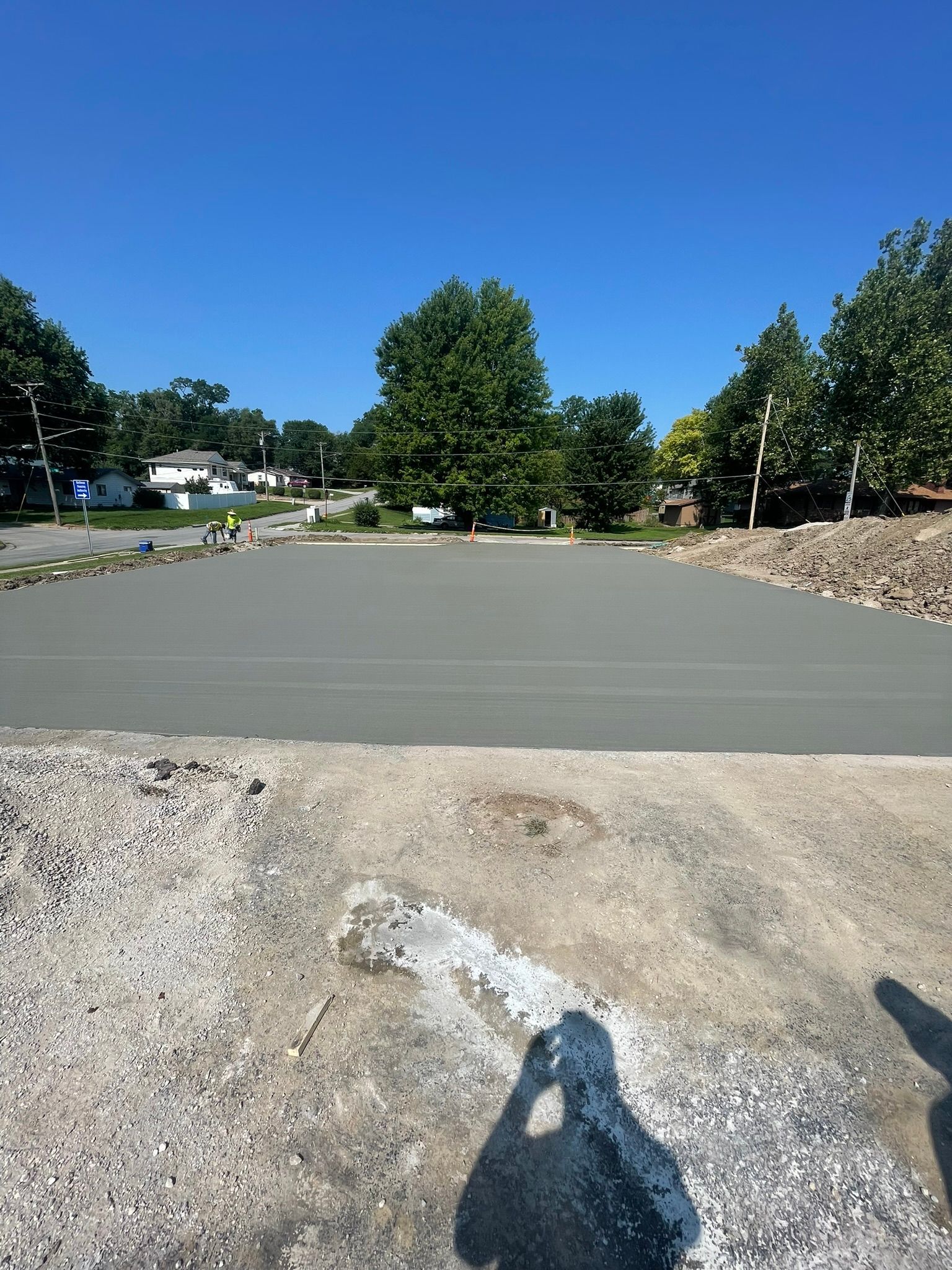 A shadow of a person is cast on a concrete surface.