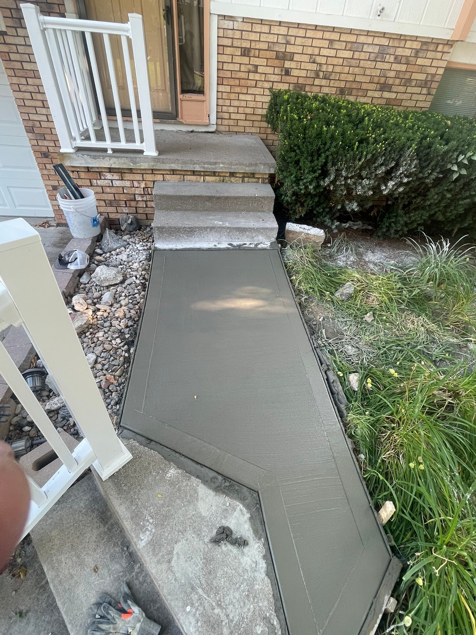 A concrete walkway is being built in front of a house.
