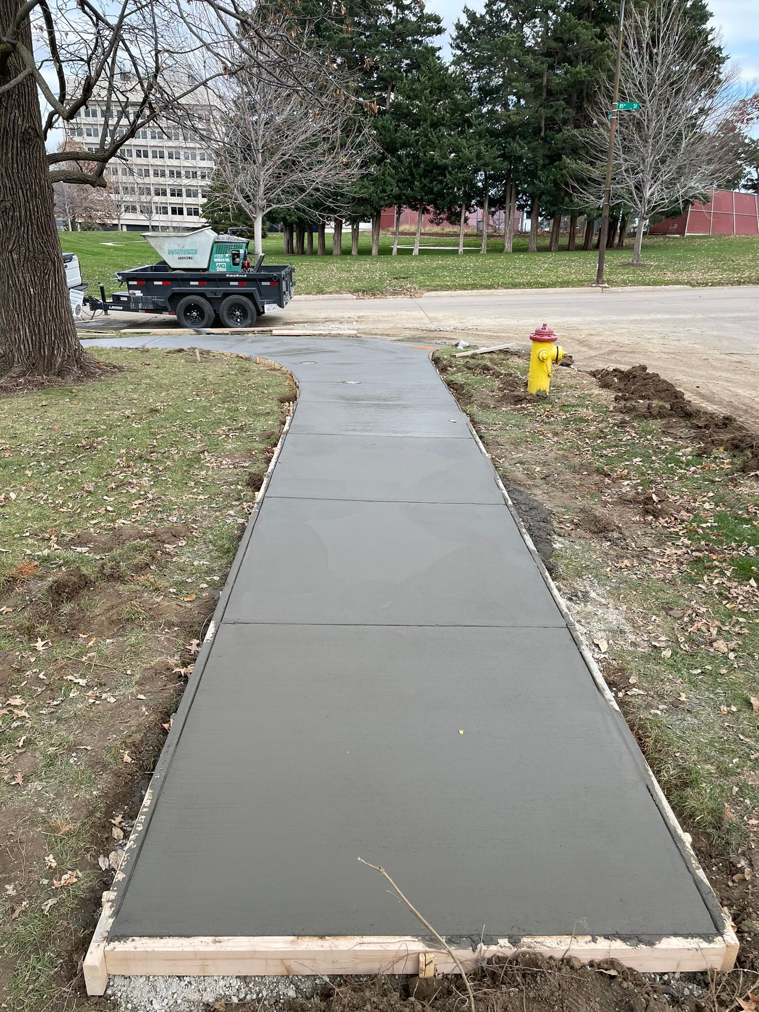 A concrete walkway is being built next to a fire hydrant.