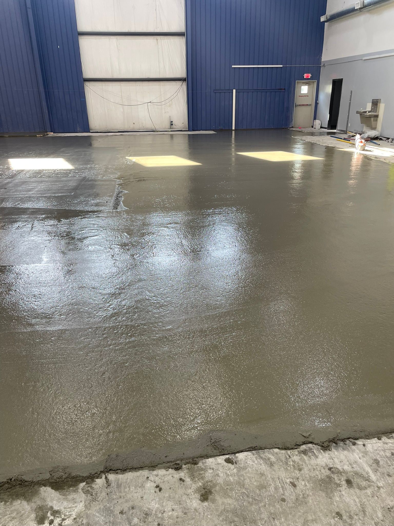 A concrete floor is being poured in a building.