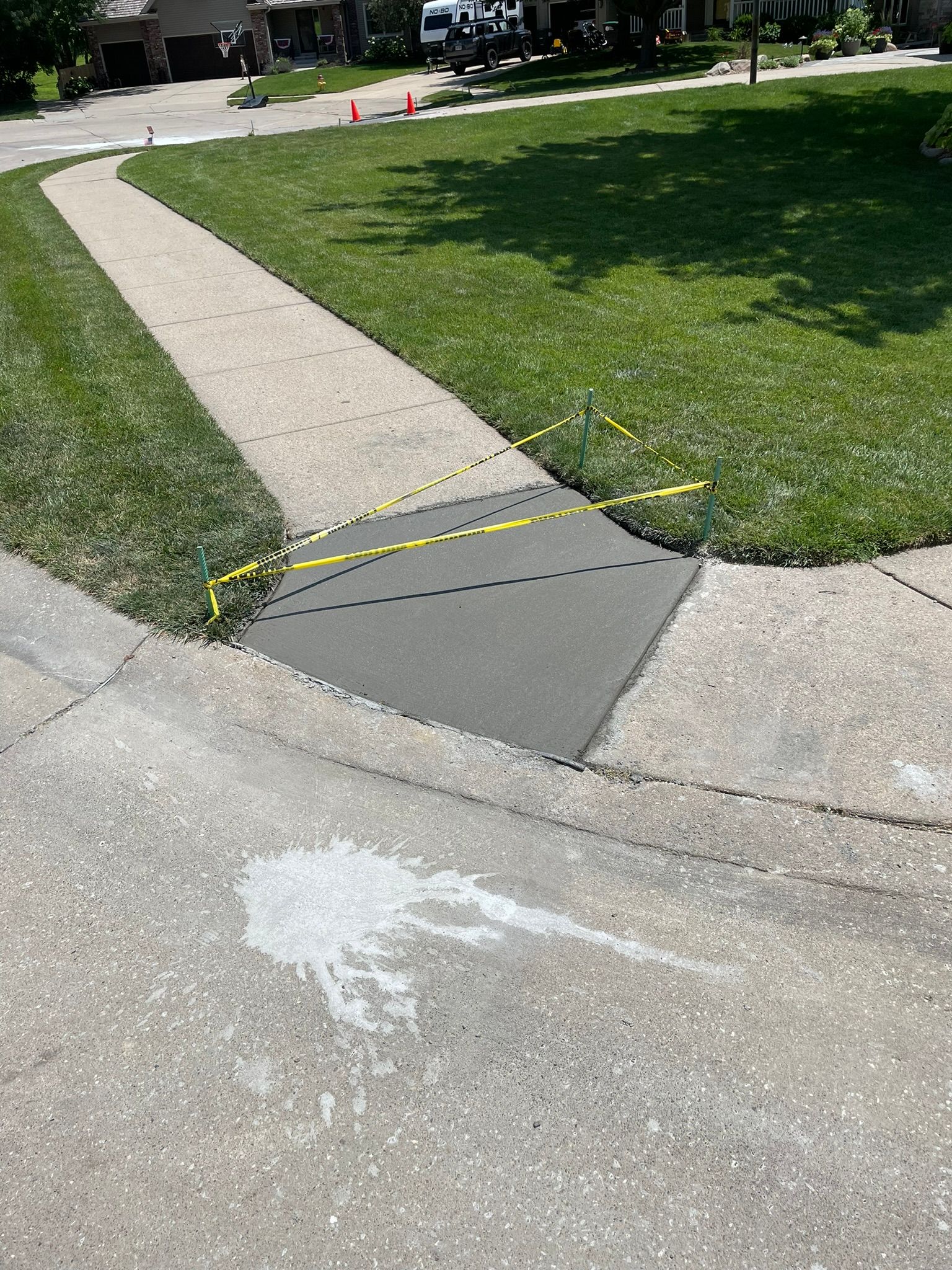 A sidewalk with a curb and grass on the side of it.