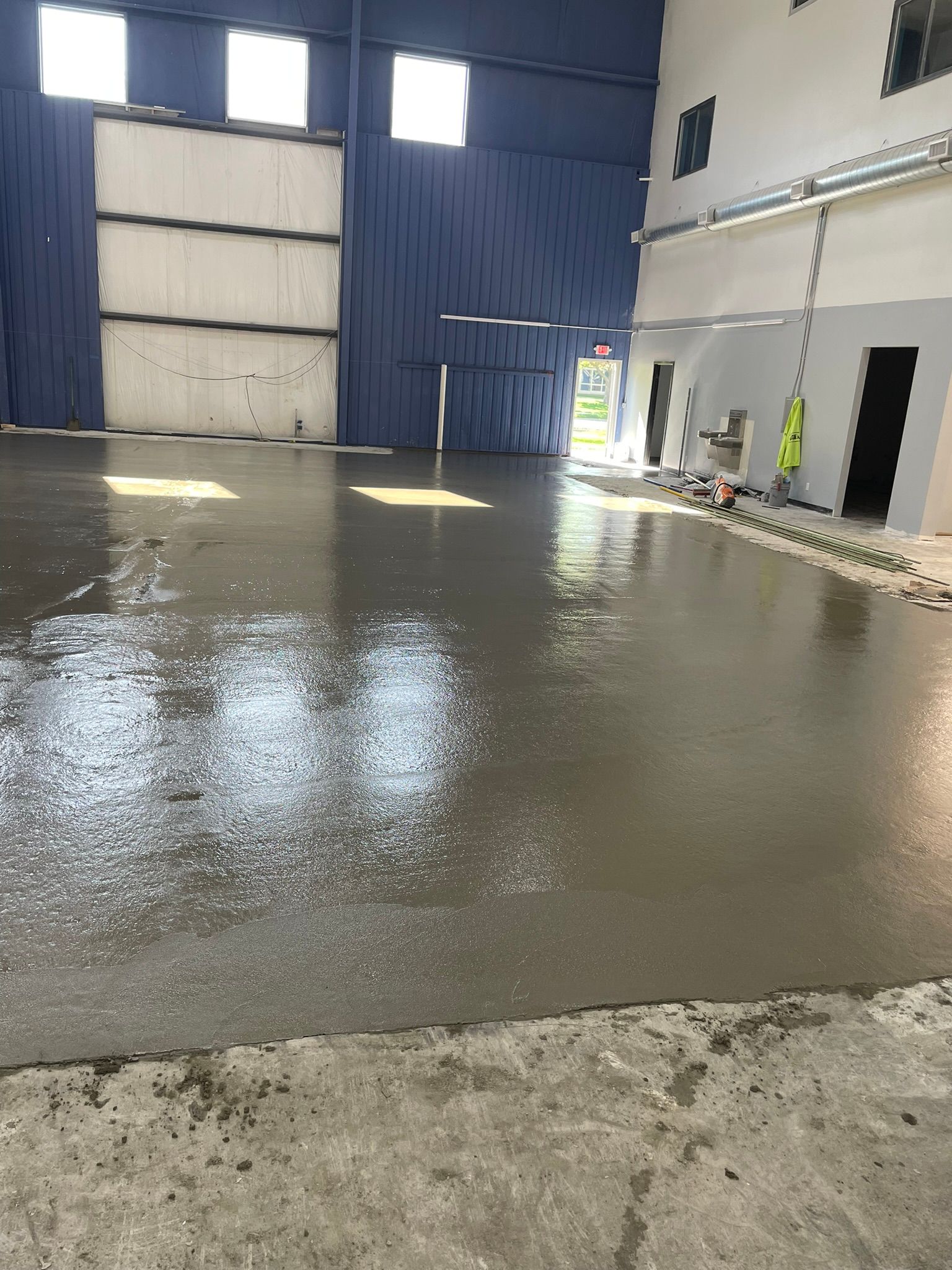 A concrete floor is being poured in a large building.