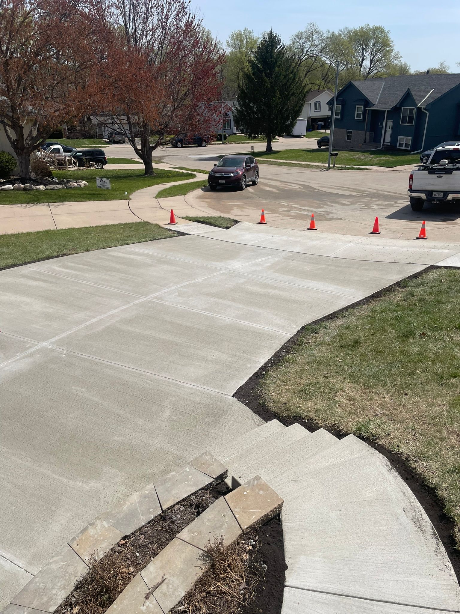 A concrete driveway with a truck parked on the side of it.