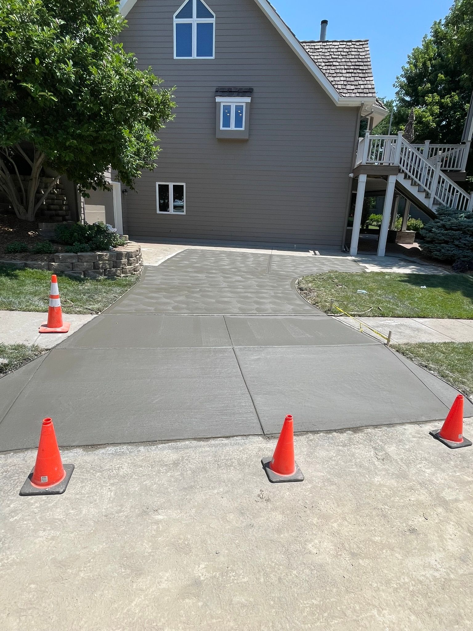 A concrete driveway is being built in front of a house.