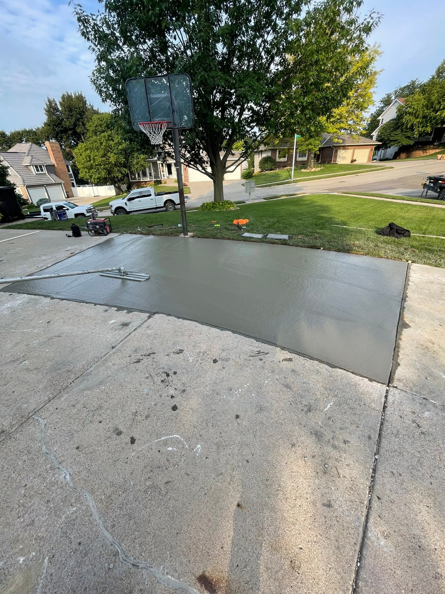 A basketball hoop is sitting on top of a concrete driveway.