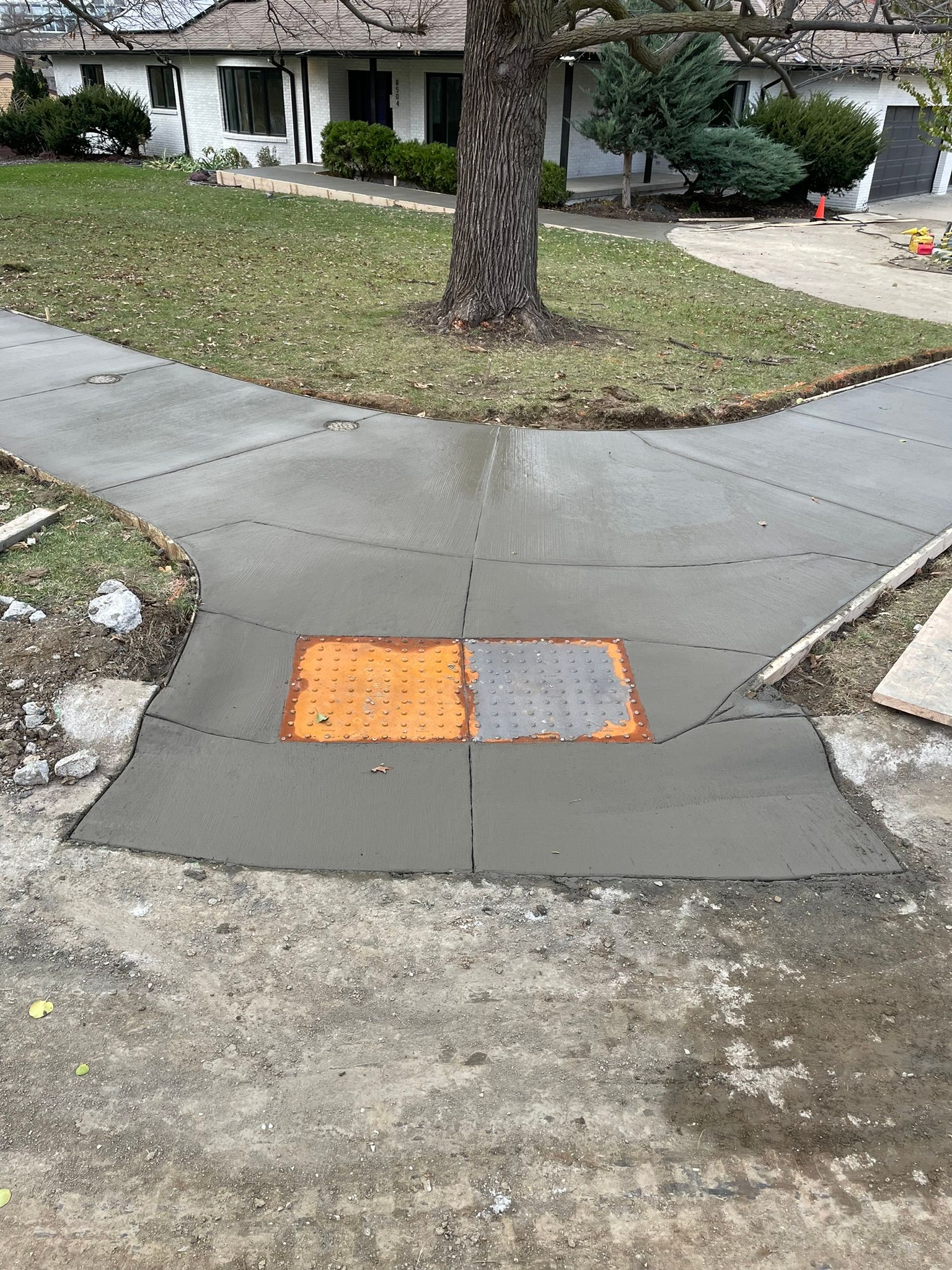 A concrete walkway is being built in front of a house.
