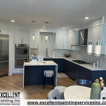 A kitchen with blue cabinets, white cabinets, stainless steel appliances and a large island.