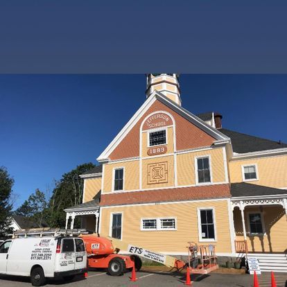 A large yellow building with a white van parked in front of it.