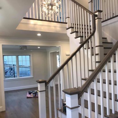 A staircase in a house with a chandelier hanging from the ceiling.