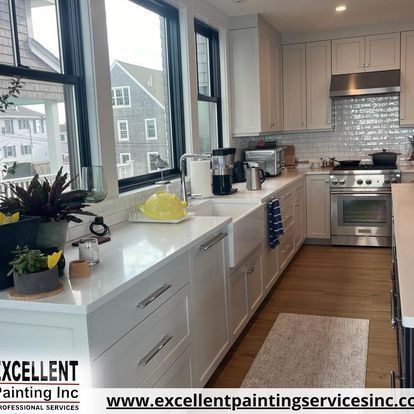 A kitchen with white cabinets, stainless steel appliances, and a sink.