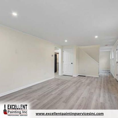 An empty basement with hardwood floors and white walls.