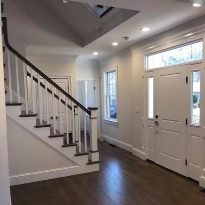 A hallway with stairs and a door in a house.