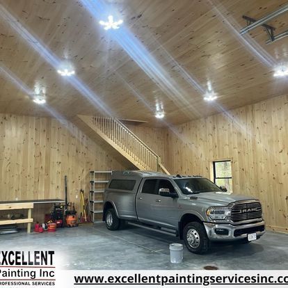 A truck is parked in a garage with wooden walls.