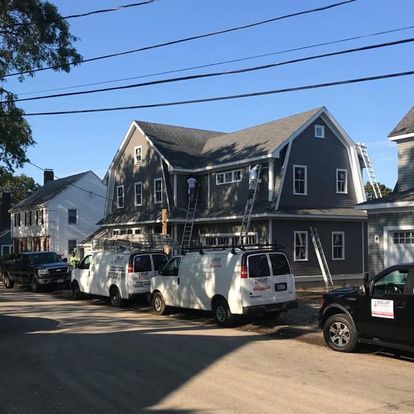A row of vans parked in front of a large house.