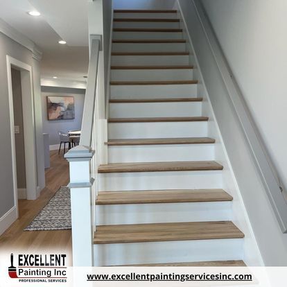 A white staircase with wooden steps in a house.