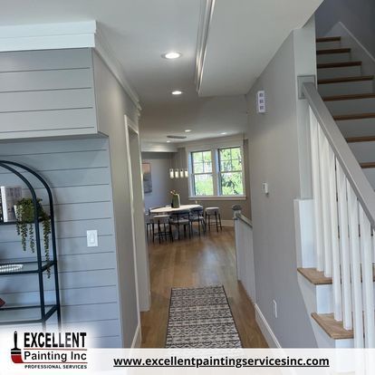 A hallway with stairs leading up to a dining room