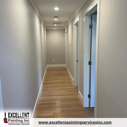 A long hallway with wooden floors and white walls.