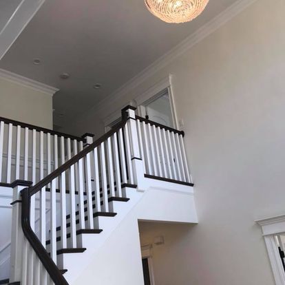 A staircase in a house with a chandelier hanging from the ceiling.