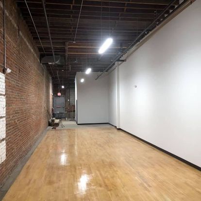 An empty room with hardwood floors and white walls.