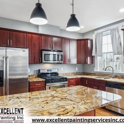 A kitchen with stainless steel appliances, granite counter tops, and wooden cabinets.