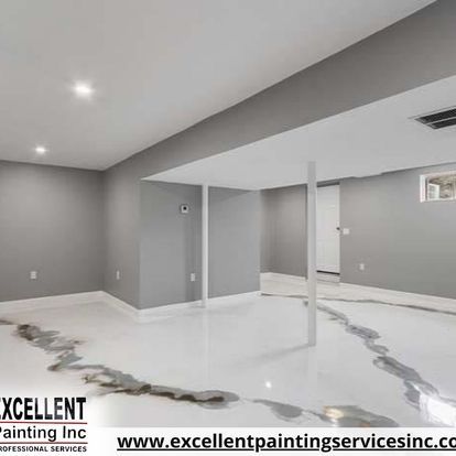 An empty basement with a white floor and gray walls.