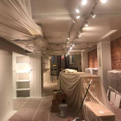 A room that is being painted with a mop and buckets.