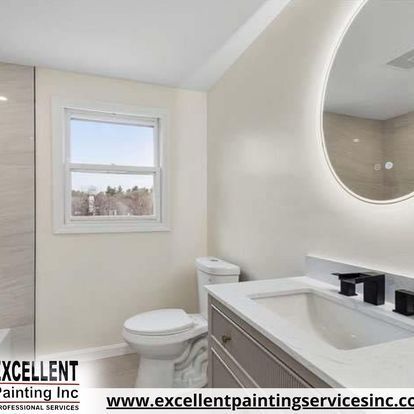 A bathroom with a toilet, sink, mirror and window.