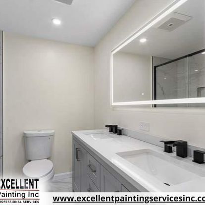 A bathroom with two sinks, a toilet, and a large mirror.