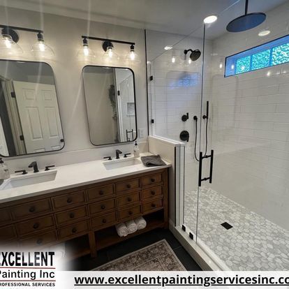 A bathroom with two sinks and a walk in shower.