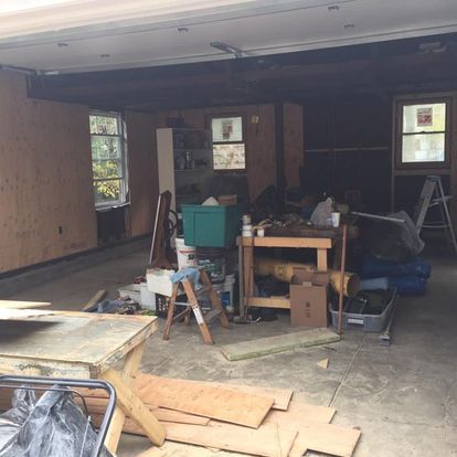 A garage filled with lots of junk and a table.