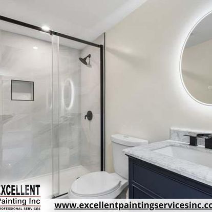 A bathroom with a toilet, sink, shower and mirror.