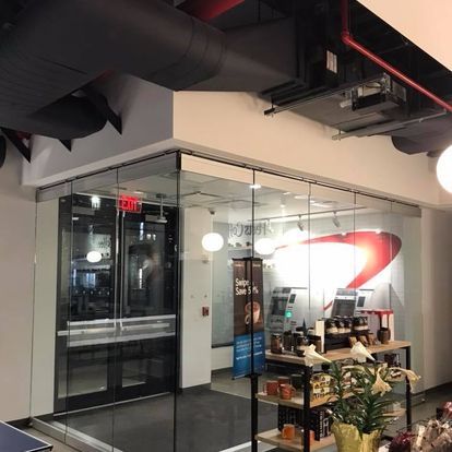 A room with a glass wall and a red exit sign