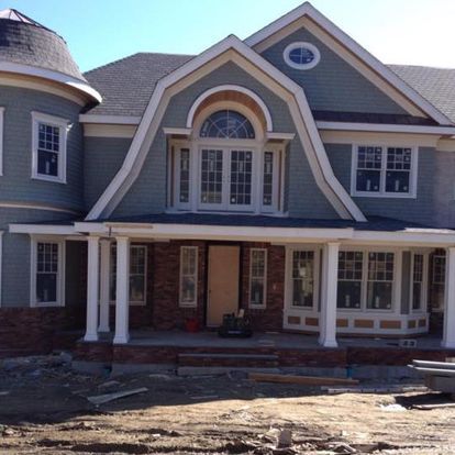 A large house with a large porch is under construction