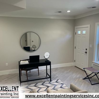 A living room with a desk, chair, and mirror.