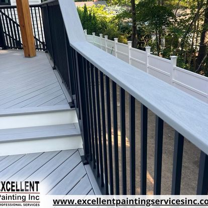 A deck with stairs and a railing painted by excellent painting services inc.