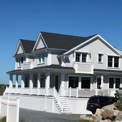 A large white house with a black suv parked in front of it