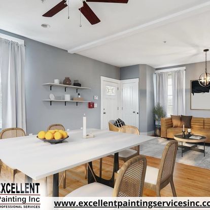 A living room with a table and chairs and a ceiling fan