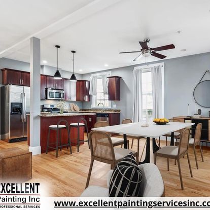 A kitchen with a table and chairs and a ceiling fan
