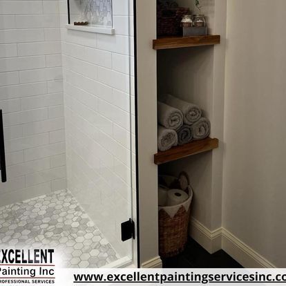 A bathroom with a shower and a shelf with towels on it.