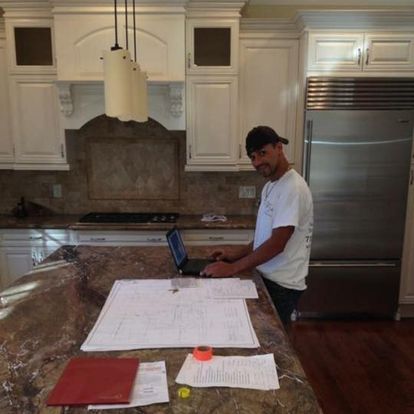 A man is working on a laptop in a kitchen