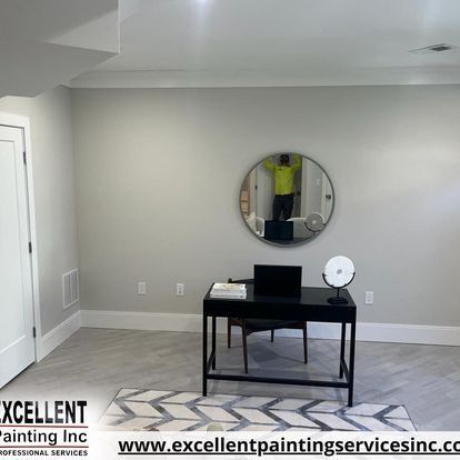 A room with a desk and a mirror on the wall.