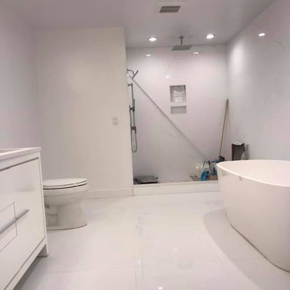 A bathroom with a tub, toilet and shower.