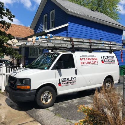 A white van is parked in front of a blue house.
