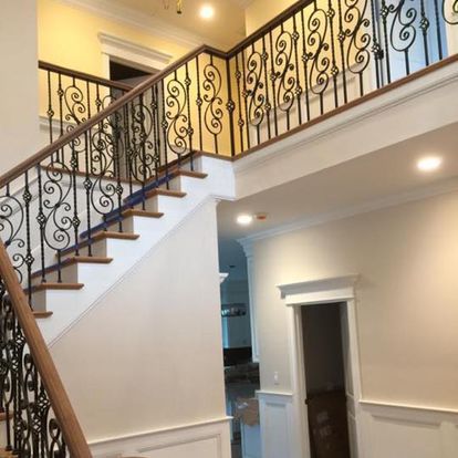 A staircase with a wrought iron railing in a house.