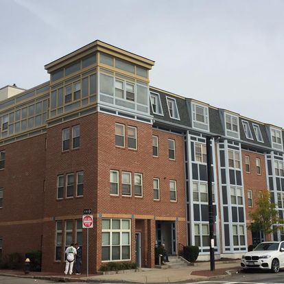 A large brick building with a stop sign on the corner