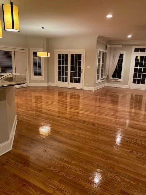 a large empty living room with hardwood floors and lots of windows
