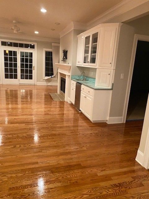 a kitchen with hardwood floors and white cabinets and a fireplace