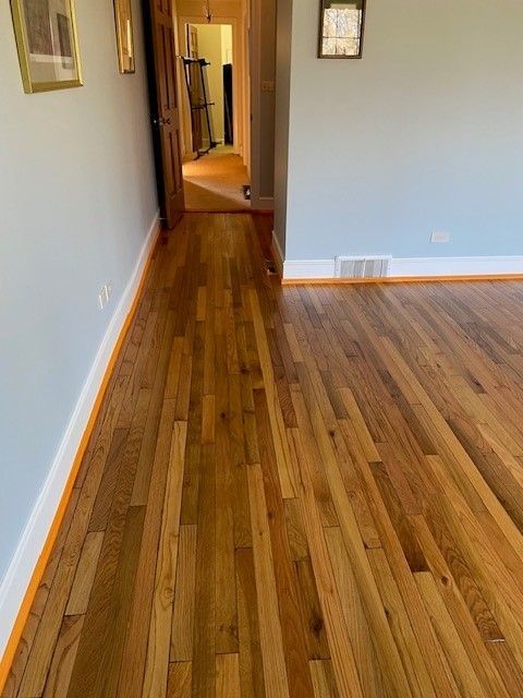 a living room with hardwood floors and a hallway leading to a kitchen