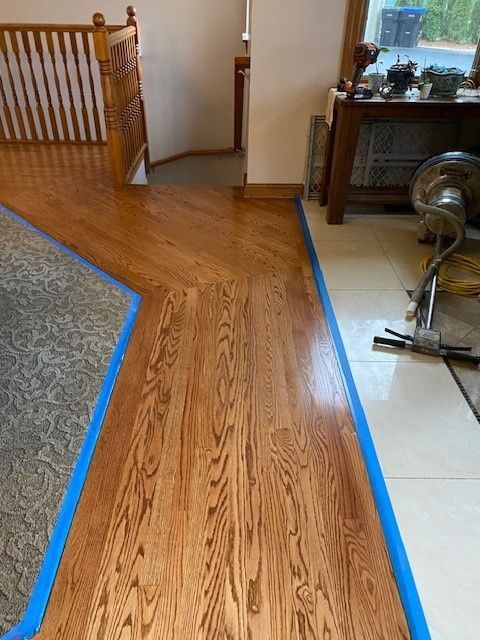 a wooden floor with blue tape around it in a living room